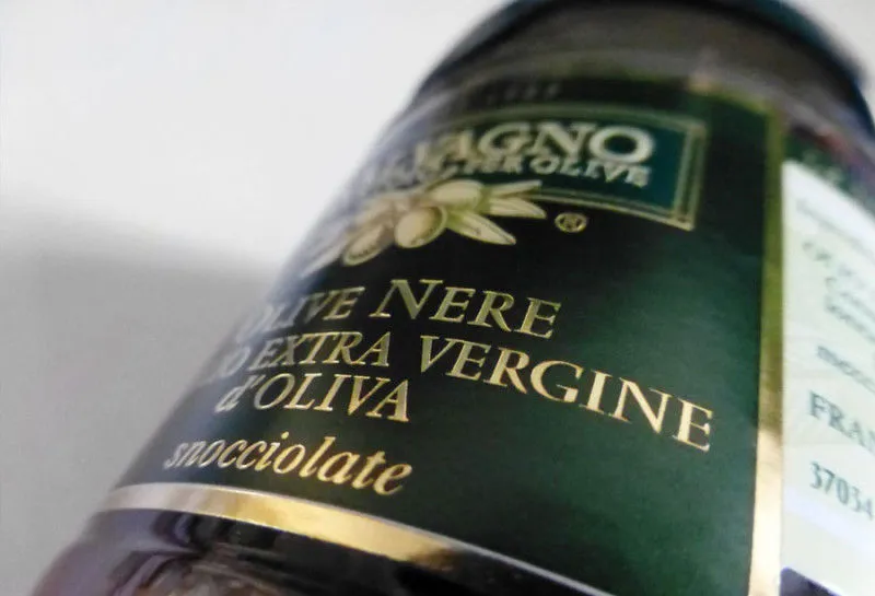 Etichetta alimentare Salvagno per olive nere in olio extravergine, fondo verde scuro con stampa in oro a caldo